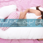 Young pregnant woman resting peacefully on a C-shaped maternity pillow in bed with pink sheets, showcasing the 'C-Shaped Pillows: Comfort Redefined' concept from FindThePerfectPillow.com.