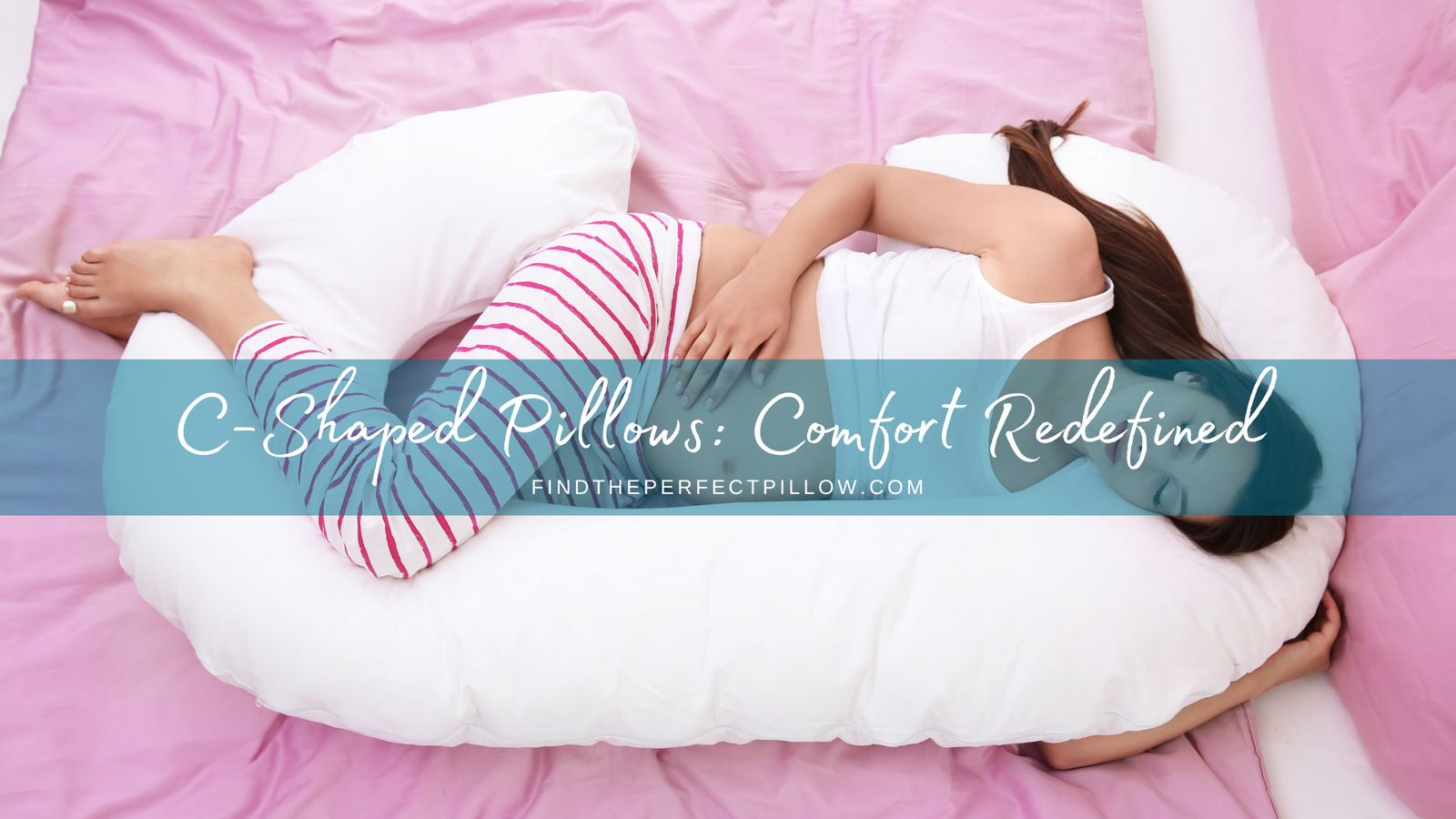 Young pregnant woman resting peacefully on a C-shaped maternity pillow in bed with pink sheets, showcasing the 'C-Shaped Pillows: Comfort Redefined' concept from FindThePerfectPillow.com.